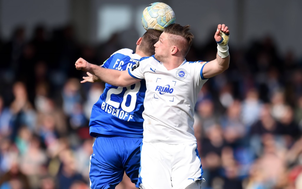 Amaury Bischoff von Hansa Rostock im Zweikampf mit LottesAndre Dej