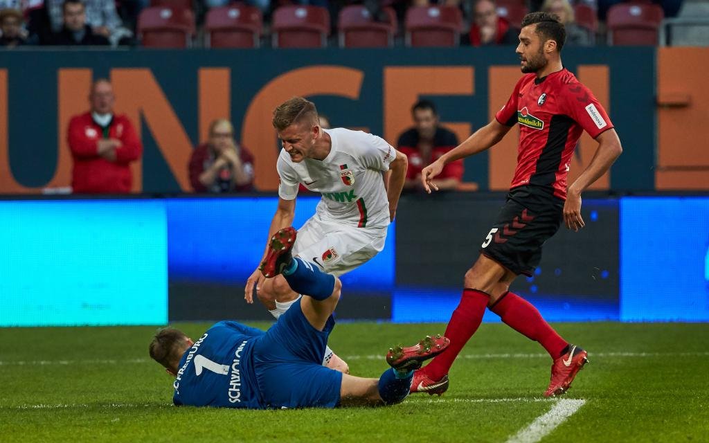 1. Bundesliga, 6. Spieltag, FC Augsburg vs. SC Freiburg, Torwart Alexander Schwolow (SCF), Alfred Finnbogason (FCA) und Manuel Gulde (SCF) in Aktion