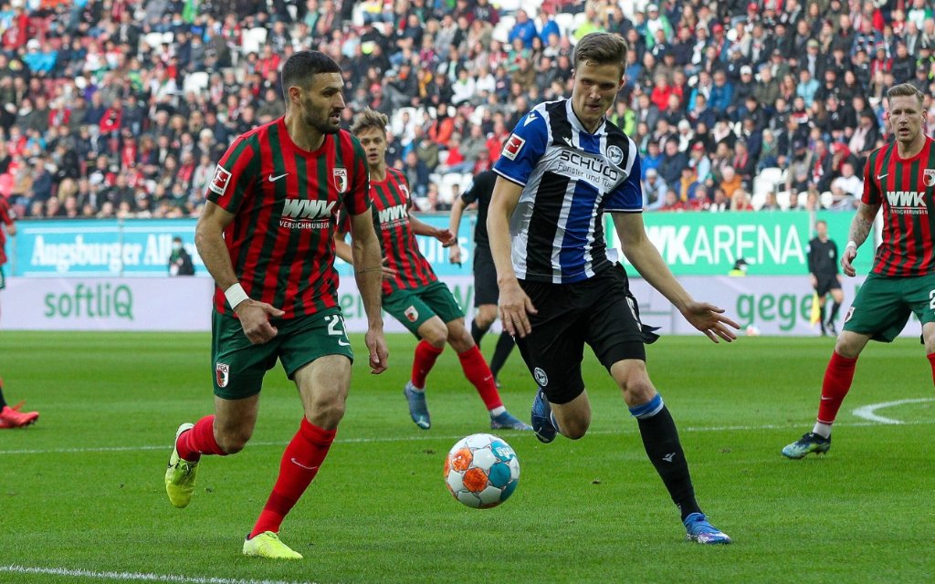 l-r: im Zweikampf, Aktion, mit Daniel Caligiuri 20 FC Augsburg und Fabian Kunze 16 Arminia Bielefeld, FC Augsburg vs. Arminia Bielefeld, 1. Bundesliga, 8. Spieltag, 17.10.2021